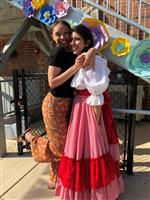 Two students at Latino Night with one dressed in cultural clothing
